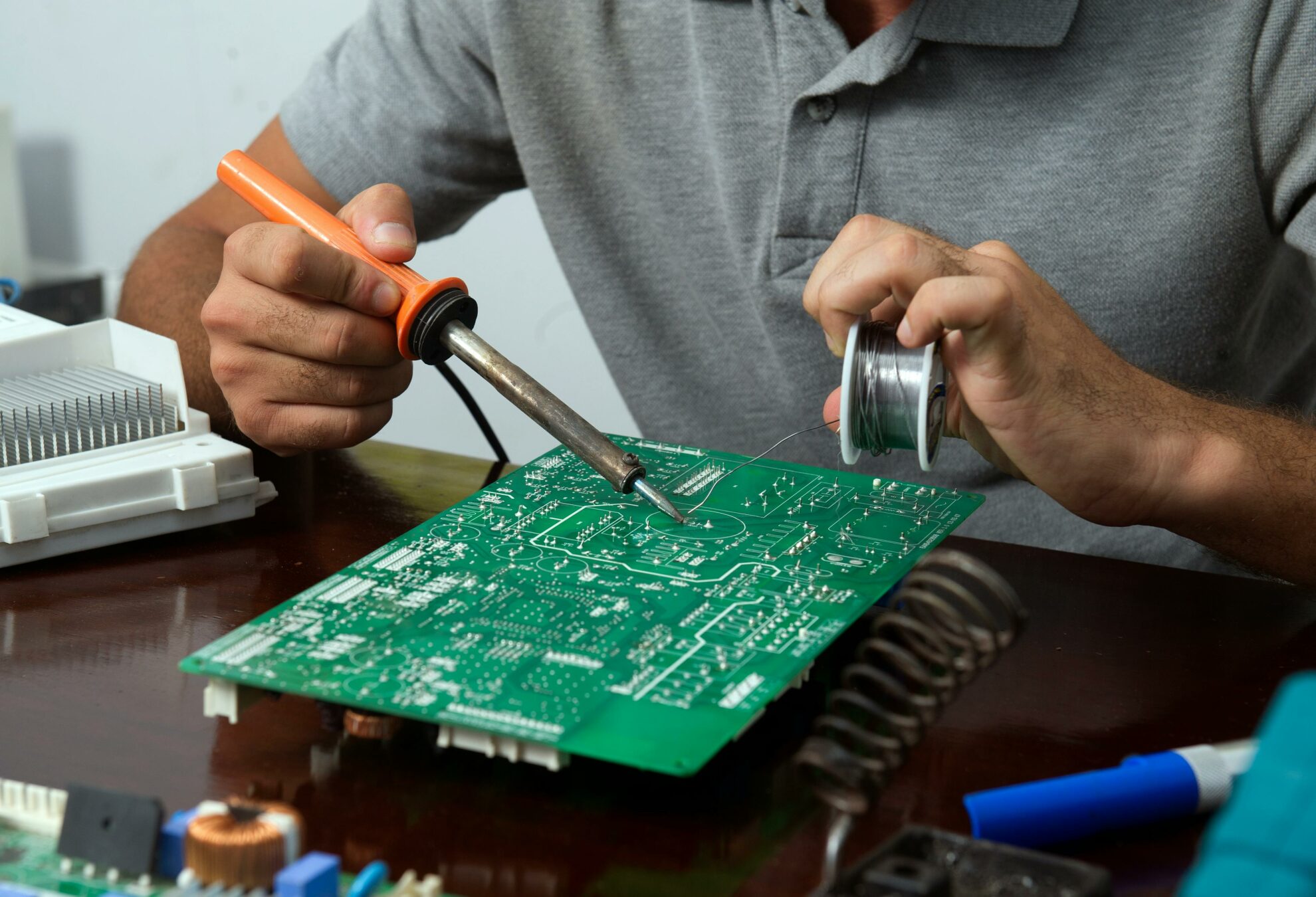 A technician repairing a circuit board in gym equipment.